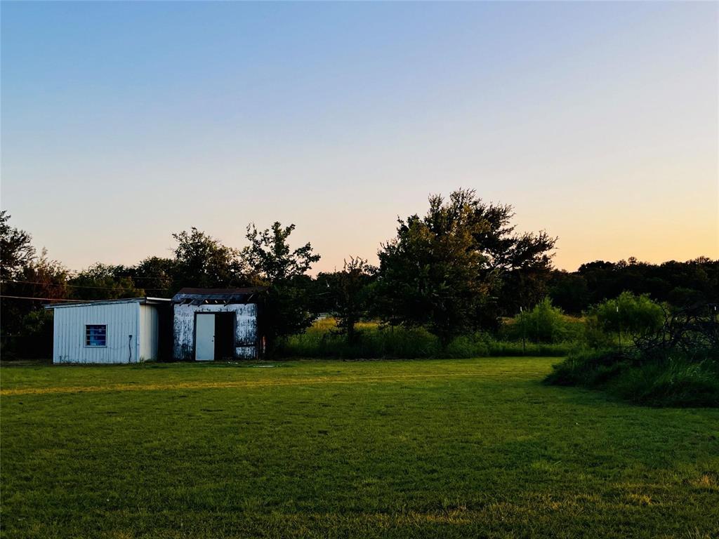 701 County Road 319 Early, TX 76802 - Photo 12 of 33 Yard at dusk featuring a yard and an outbuilding