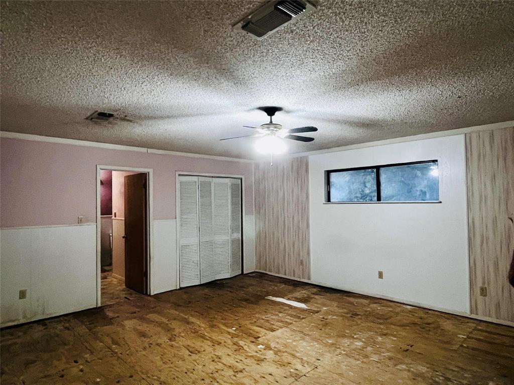 701 County Road 319 Early, TX 76802 - Photo 23 of 33 Unfurnished bedroom with a closet, ornamental molding, ceiling fan, and a textured ceiling