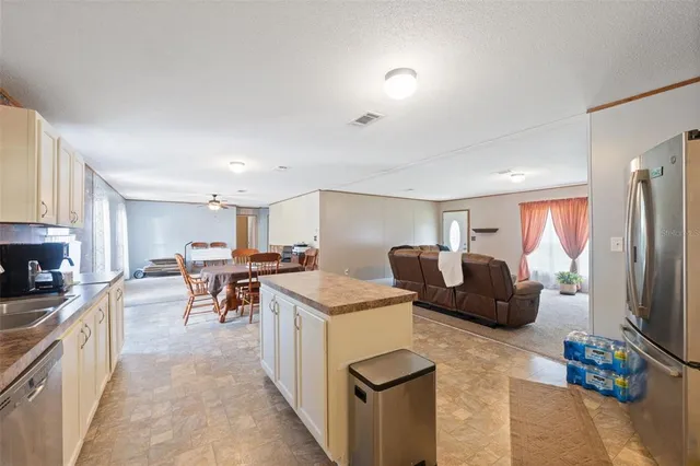 a living room with furniture a flat screen tv and a refrigerator