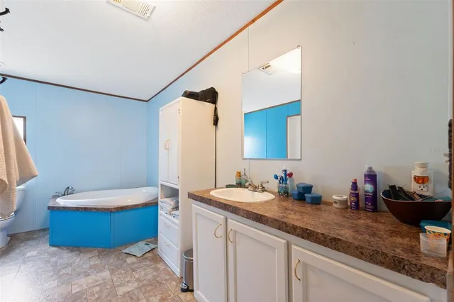 a en suite bathroom with a granite countertop sink and a mirror