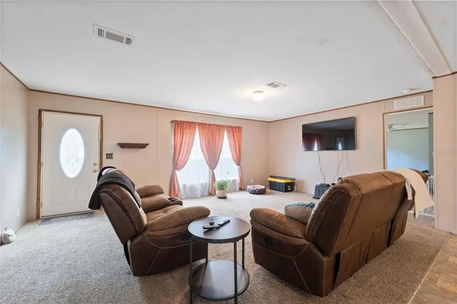 a living room with furniture a large window and flowerpot
