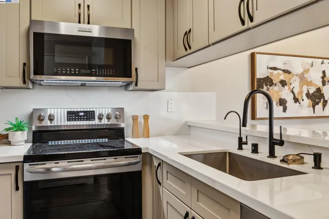 a kitchen with stainless steel appliances granite countertop a sink stove and microwave