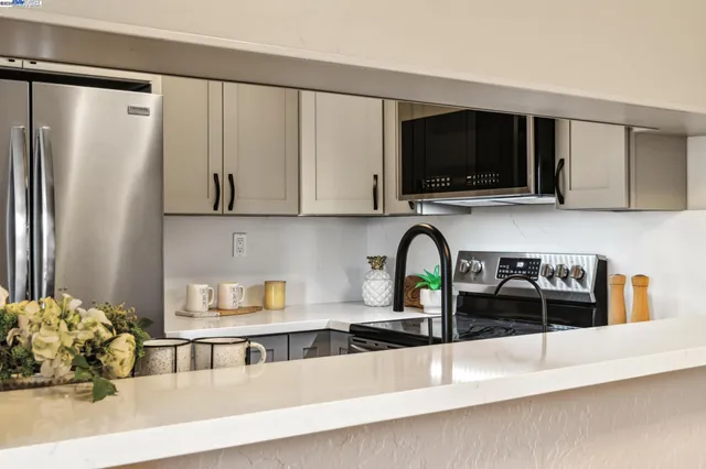 a kitchen with stainless steel appliances granite countertop a refrigerator and a stove top oven