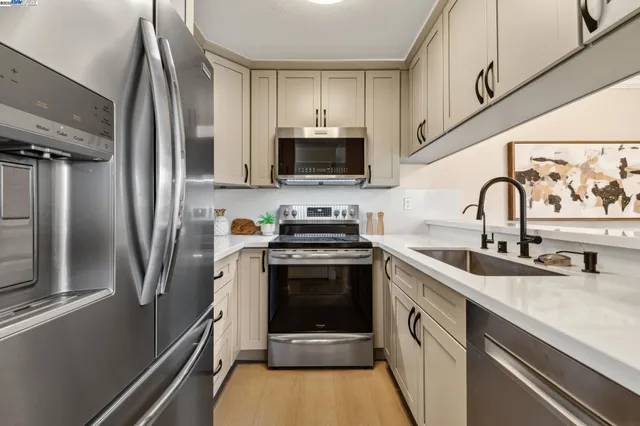 a kitchen with stainless steel appliances a stove sink and refrigerator