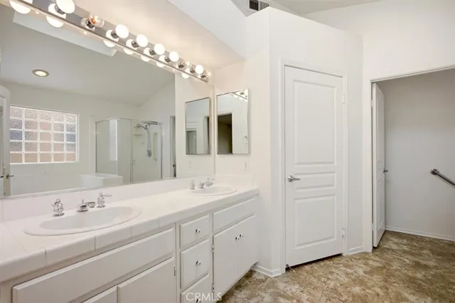 a spacious bathroom with a shower sink and mirror