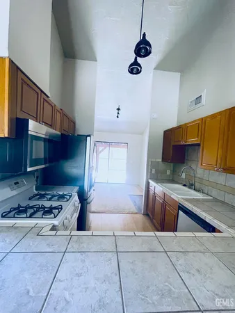 a kitchen with stainless steel appliances granite countertop a stove a sink and a microwave