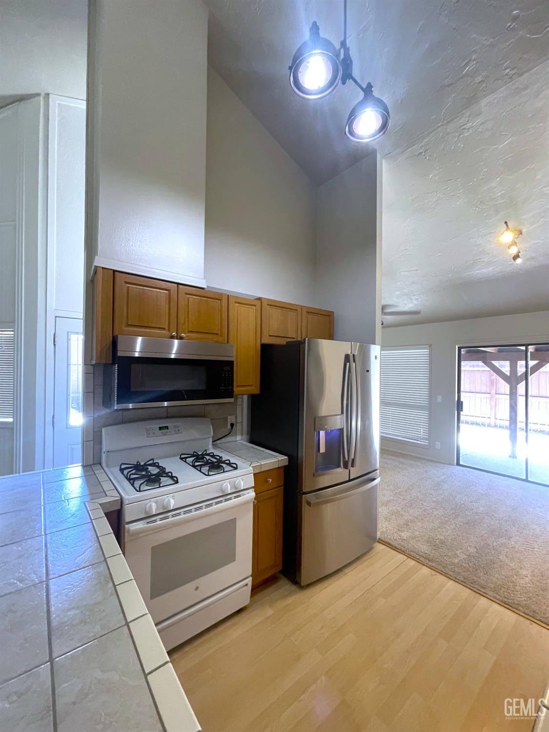 Undisclosed Address Tehachapi, CA 93561 - Photo 11 of 29 a kitchen with stainless steel appliances a stove a sink and a refrigerator