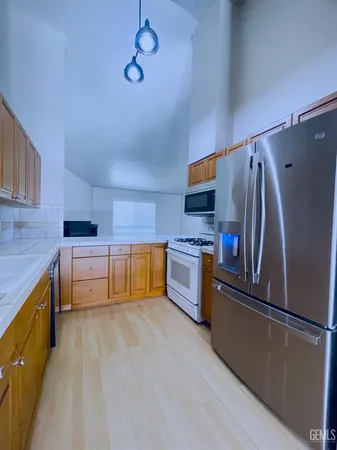 a kitchen with stainless steel appliances a refrigerator and a stove top oven