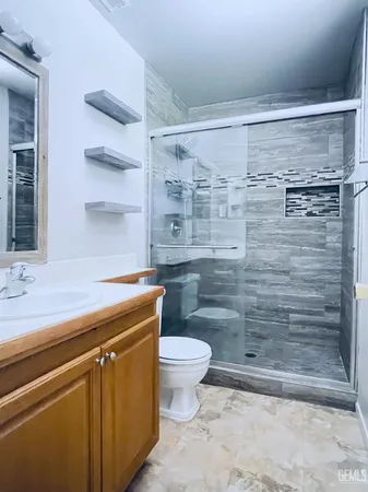 a bathroom with a granite countertop toilet and a sink