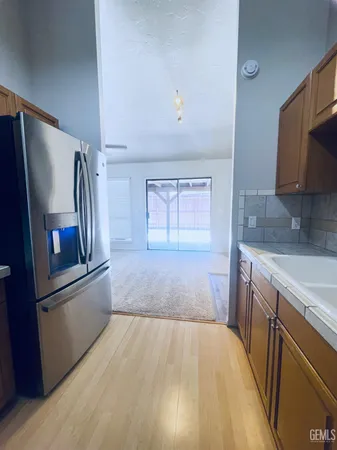a kitchen with granite countertop a refrigerator and a sink