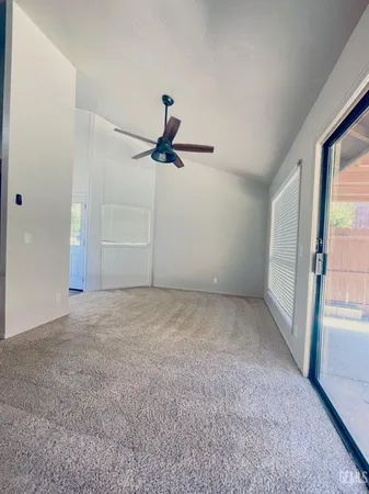 a view of a livingroom with a ceiling fan and window