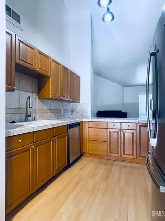 a kitchen with granite countertop a sink cabinets stainless steel appliances and a counter space