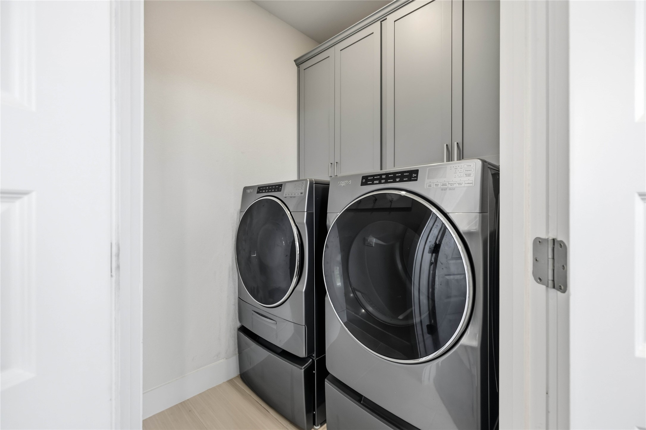 1722 Rowdy Loop, Unit 7 Leander, TX 78641 - Photo 13 of 37 Modern laundry room featuring sleek stainless steel washer and dryer units, complemented by ample storage in overhead cabinets. Included in Rental!