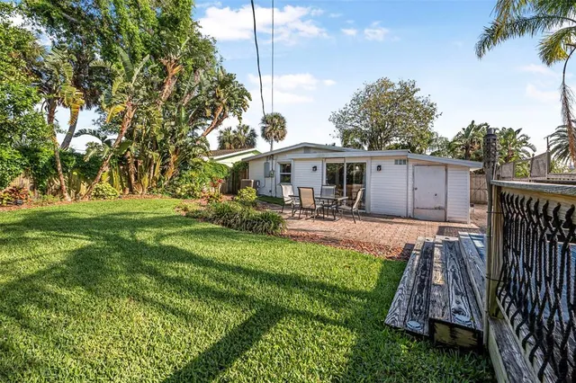 a view of a house with backyard and wooden fence