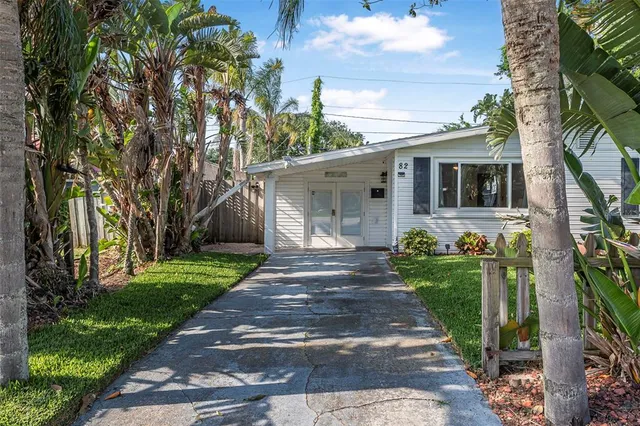 a front view of a house with a yard and trees