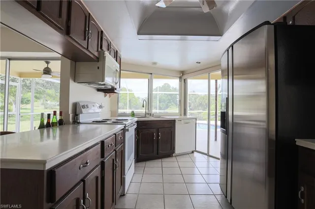 a kitchen with stainless steel appliances granite countertop a refrigerator a sink a stove and island