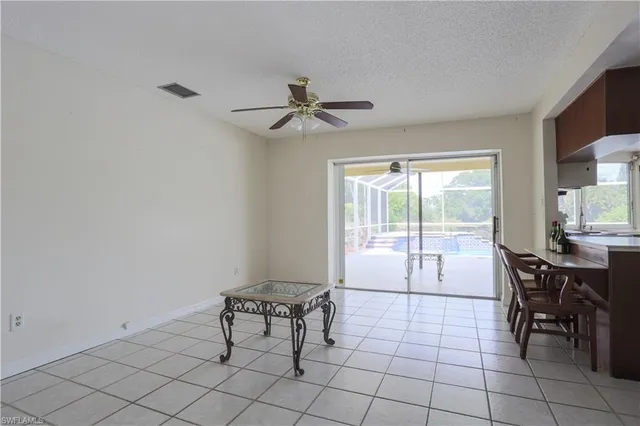 a dining room with furniture and chandelier fan