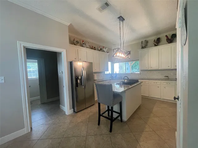 a kitchen with a refrigerator a sink dishwasher a dining table and chairs