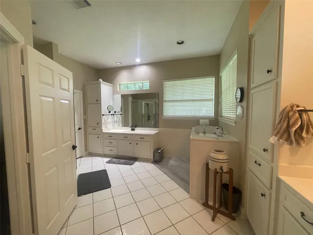 a large bathroom with a sink a large mirror and a shower