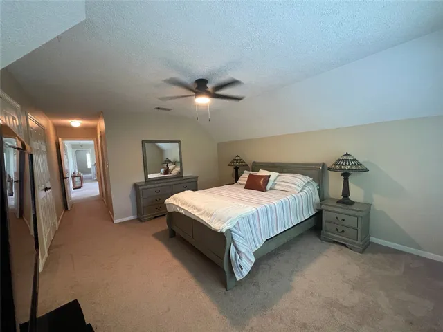 a spacious bedroom with a bed and a chandelier