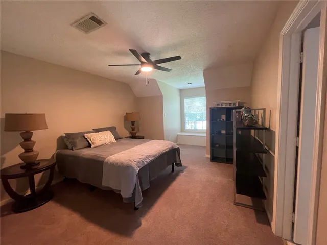 a bedroom with a bed and a ceiling fan