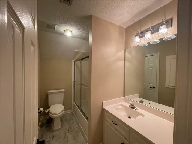 a bathroom with a sink vanity mirror and toilet