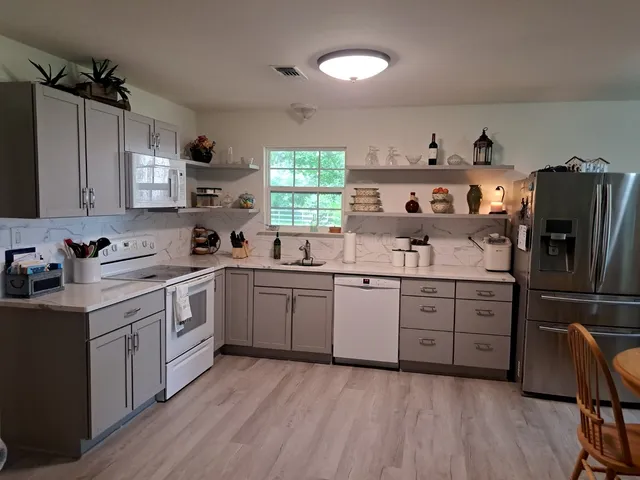 a kitchen with stainless steel appliances a sink cabinets and wooden floor