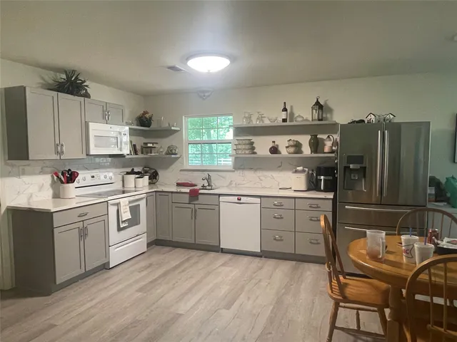a kitchen with granite countertop white cabinets and white appliances