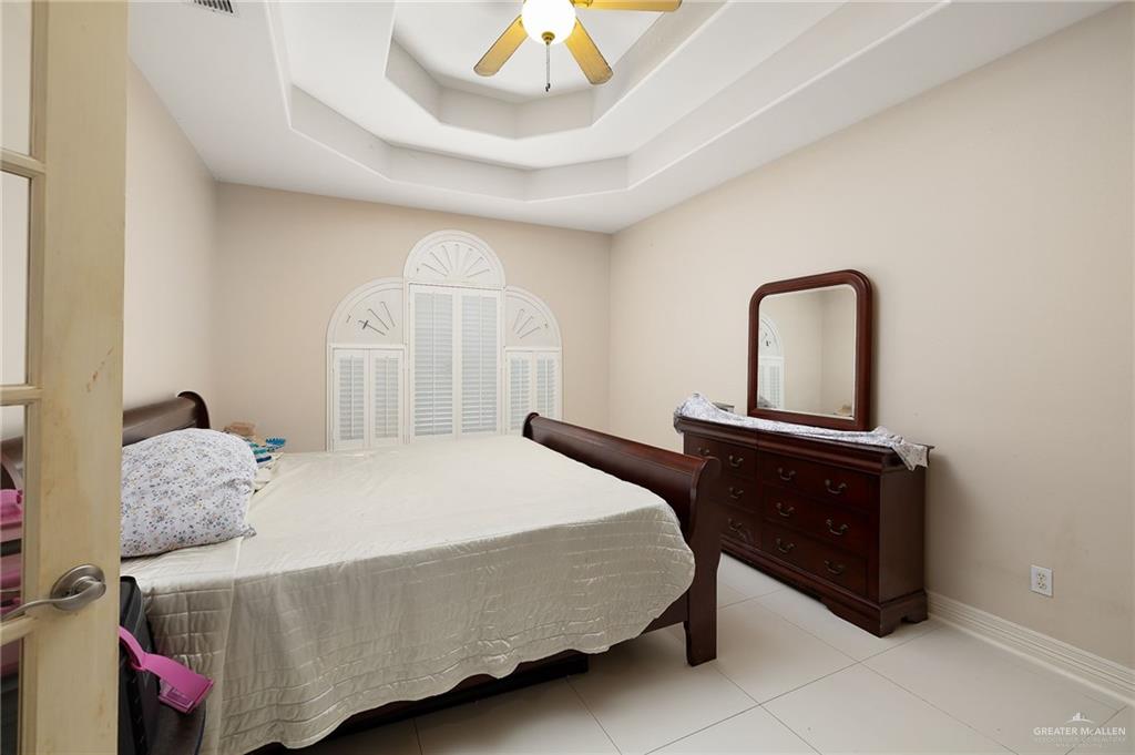 519 East Earling Road Alamo, TX 78516 - Photo 9 of 16 a bedroom with a bed and a chandelier