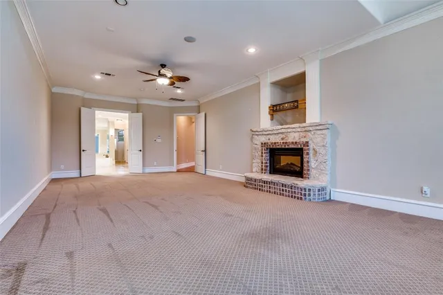 an empty room with windows and a ceiling fan