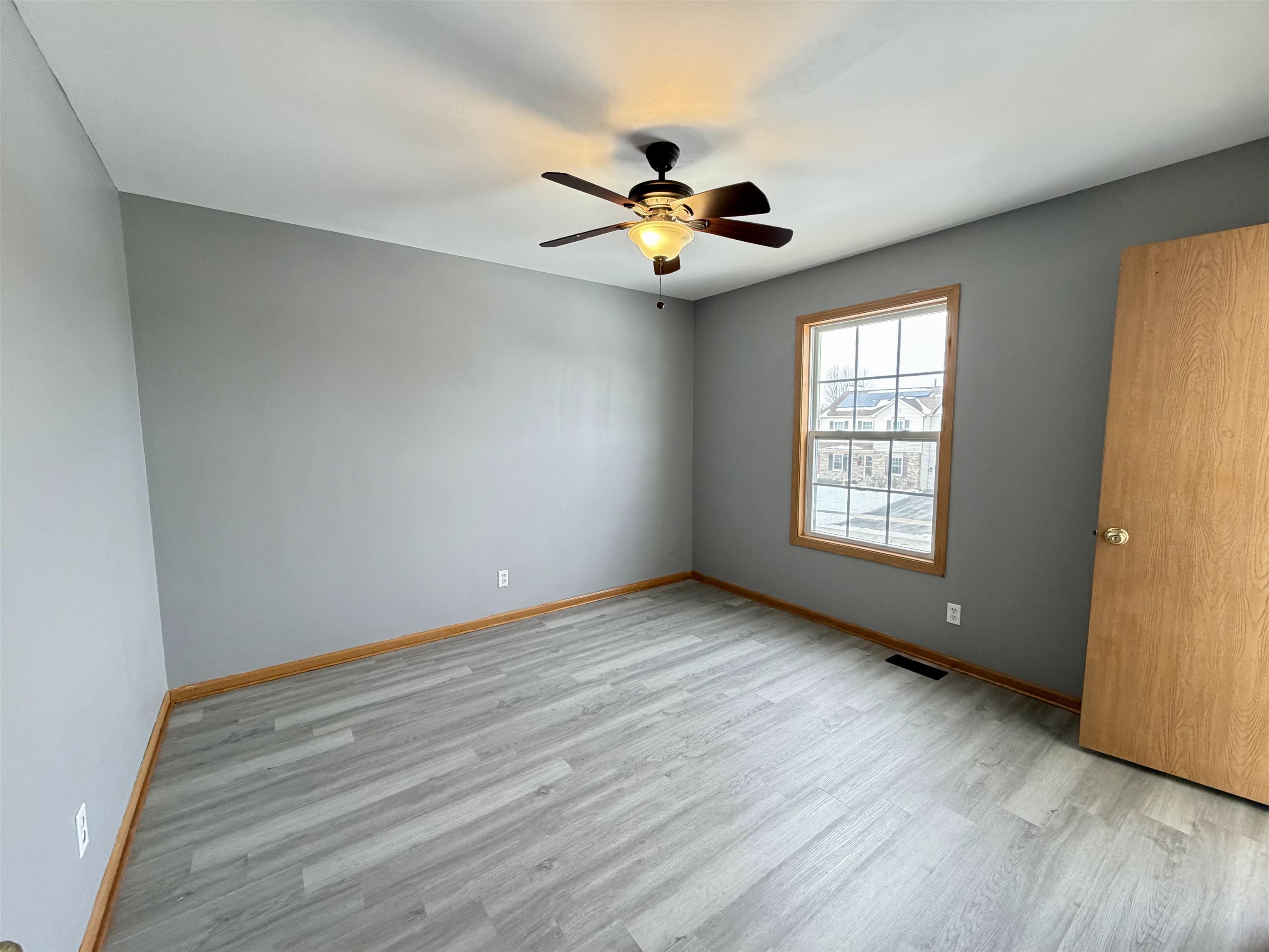 2424 Winfield Lane Belvidere, IL 61008 - Photo 20 of 30 an empty room with wooden floor fan and windows