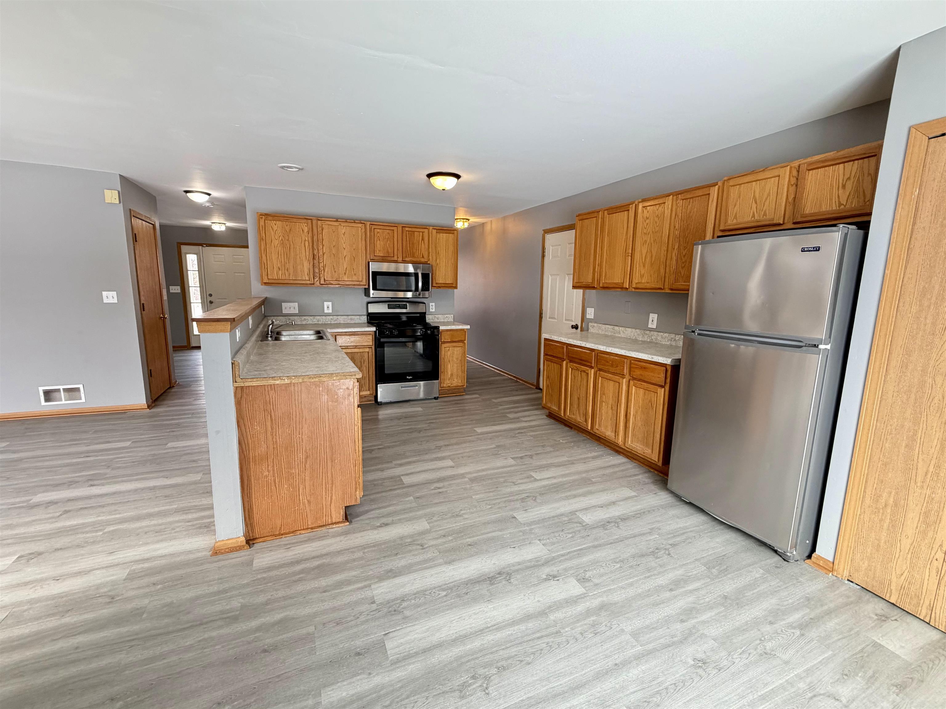 2424 Winfield Lane Belvidere, IL 61008 - Photo 7 of 30 a kitchen with refrigerator cabinets and wooden floor