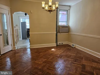 a view of a livingroom with wooden floor and chandelier