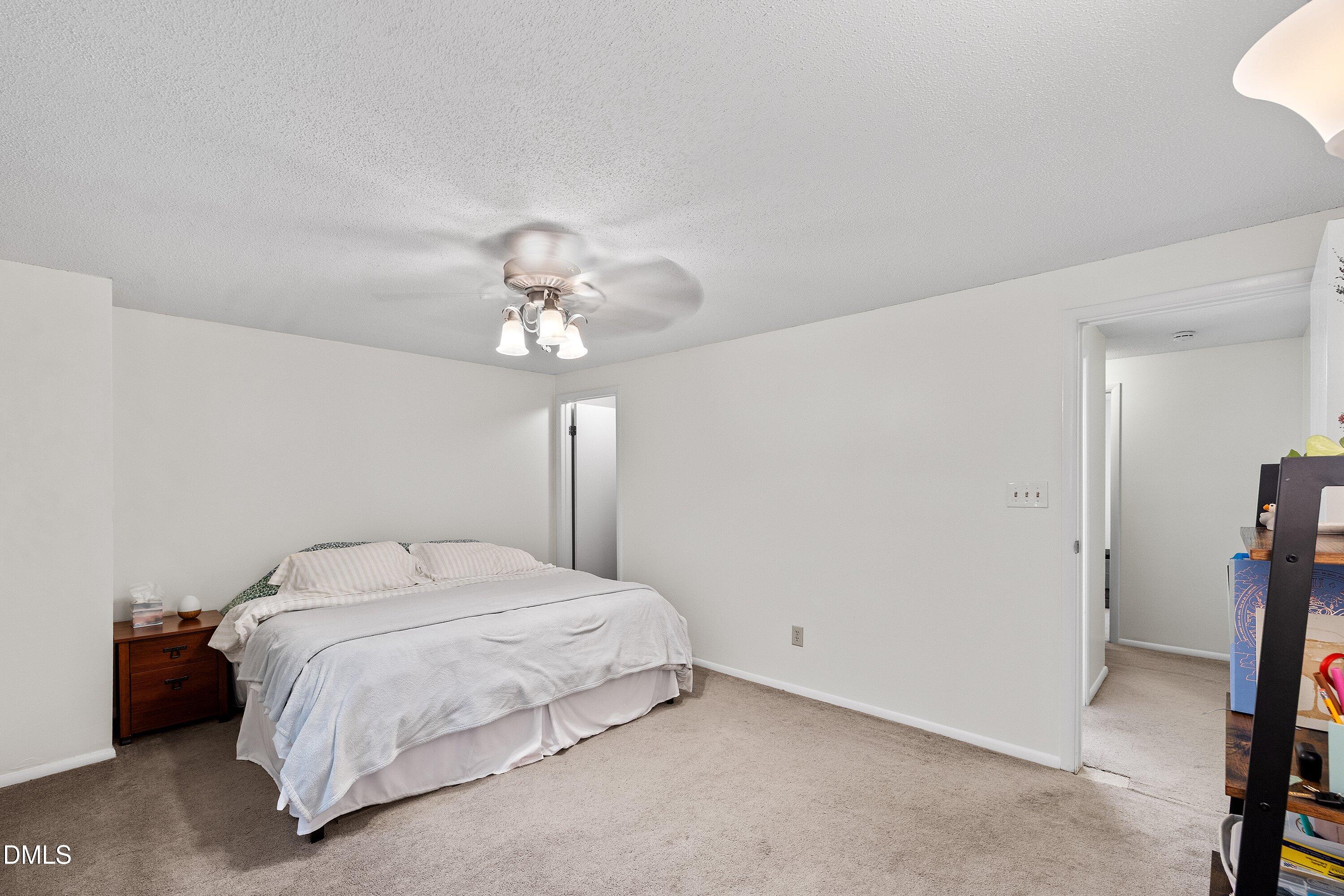7729 Bernadette Lane Raleigh, NC 27615 - Photo 17 of 34 a bedroom with a bed and a chandelier