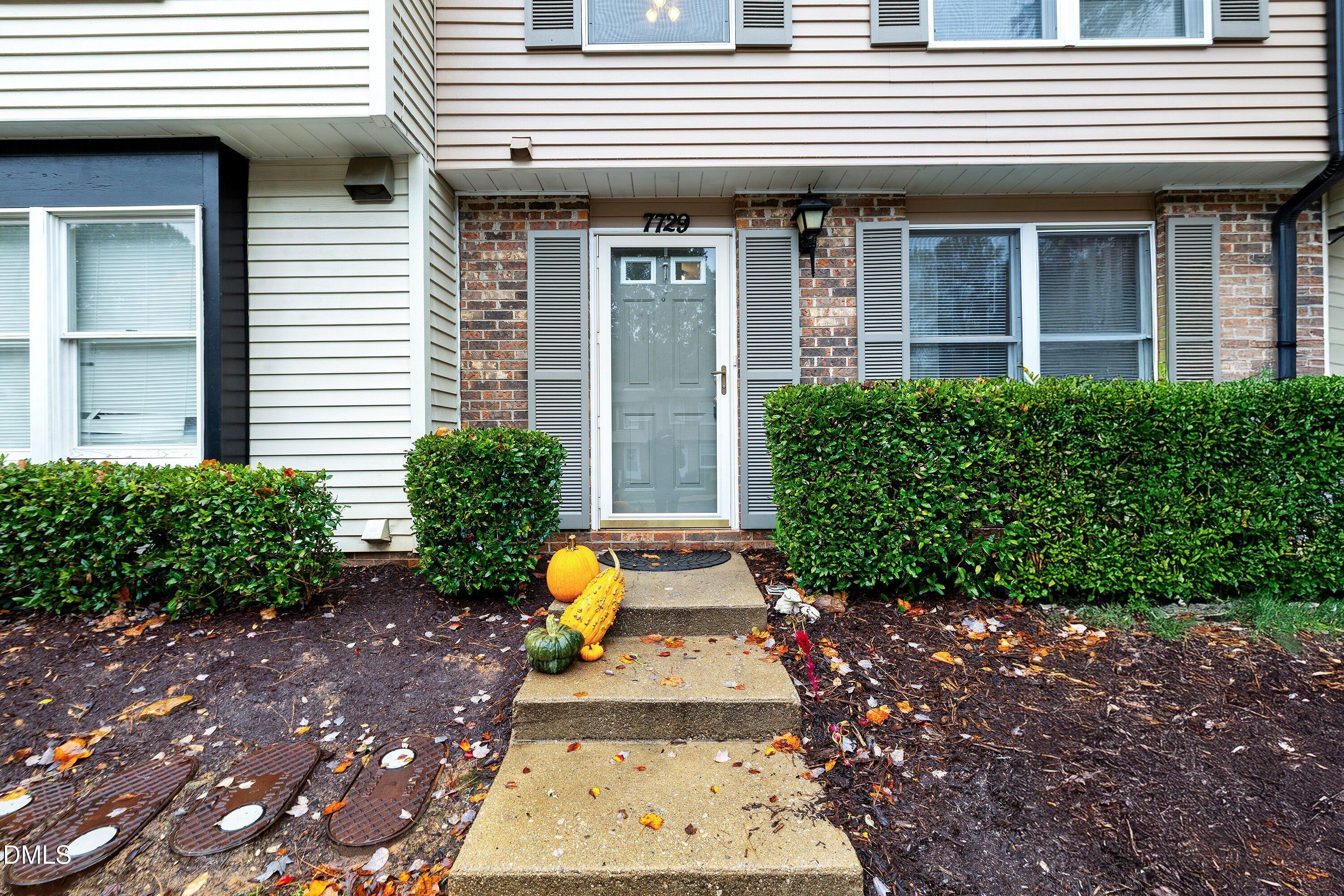 7729 Bernadette Lane Raleigh, NC 27615 - Photo 2 of 34 a view of a house with potted plants and a dining table and chairs