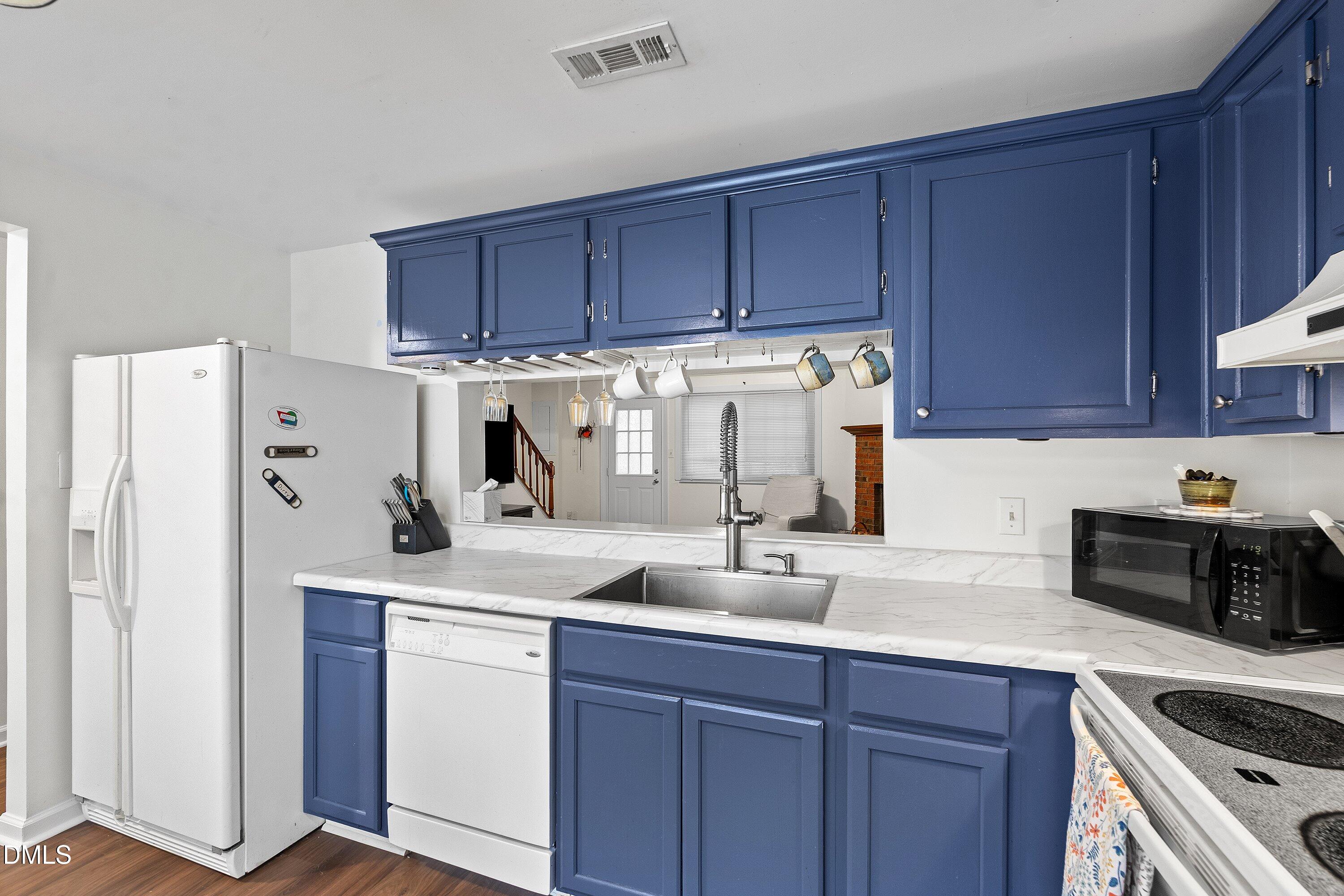 7729 Bernadette Lane Raleigh, NC 27615 - Photo 6 of 34 a kitchen with a sink a refrigerator and cabinets