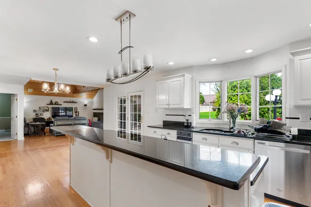 a kitchen with stainless steel appliances a sink a stove and a wooden floor