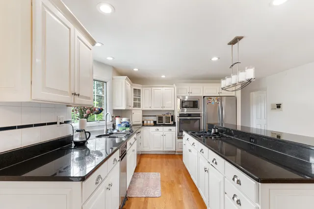 a large kitchen with granite countertop lots of counter space a sink and appliances