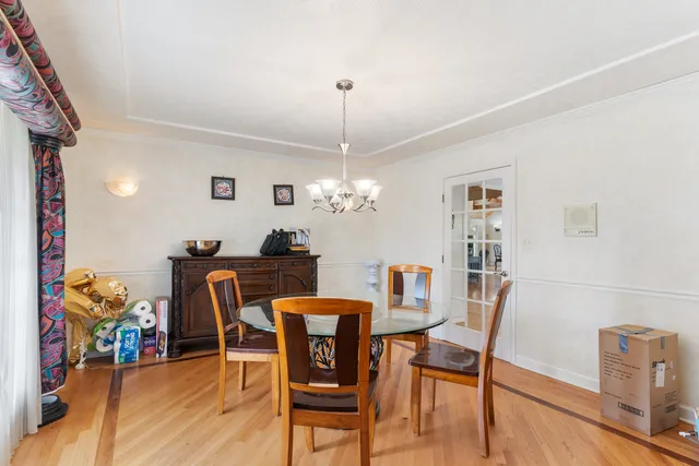 a dining room with furniture potted plants and wooden floor