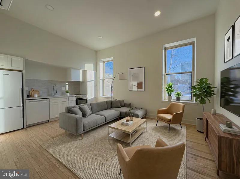 a living room with furniture and a refrigerator