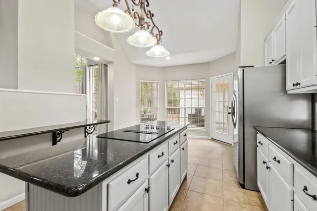 a kitchen with granite countertop a sink a counter space and stainless steel appliances