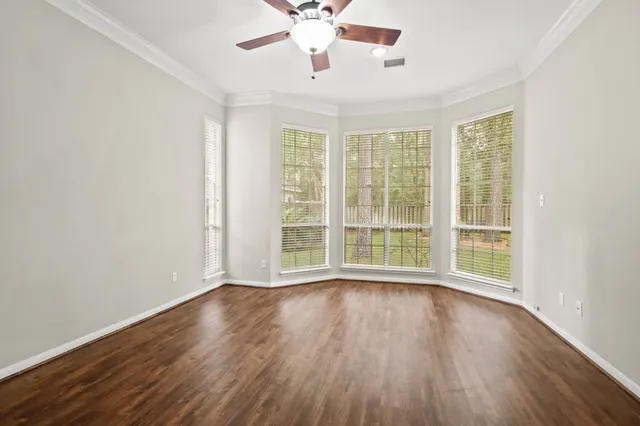 a view of wooden floor and a chandelier fan in a room