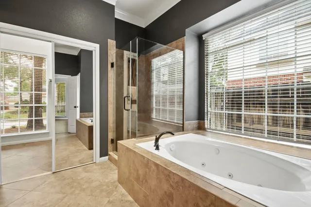 a bathroom with bathtub and windows