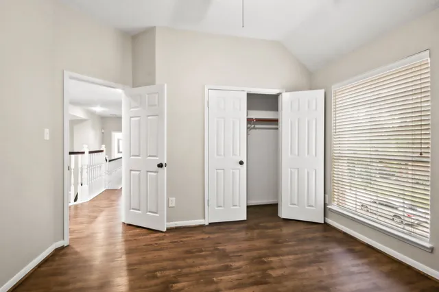 a view of empty room with wooden floor