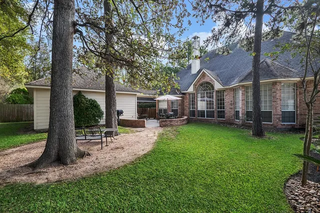 a view of a house with backyard and a tree