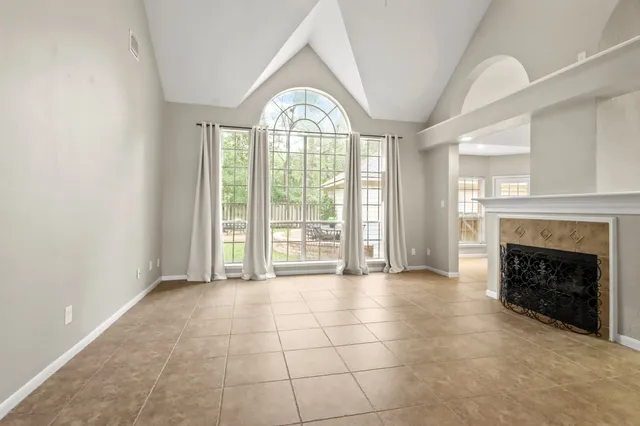 a view of an empty room with a fireplace and a window