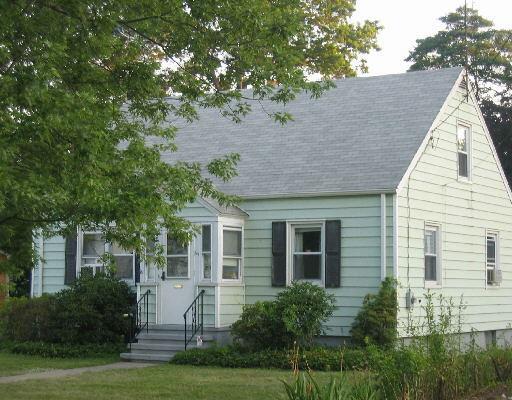 a view of house with a yard and potted plants