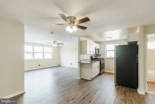 a view of a kitchen with a sink a refrigerator and wooden floor