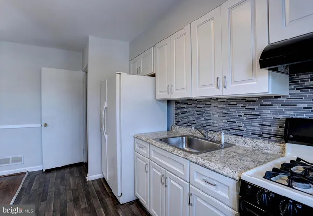 a kitchen with a sink stove and cabinets