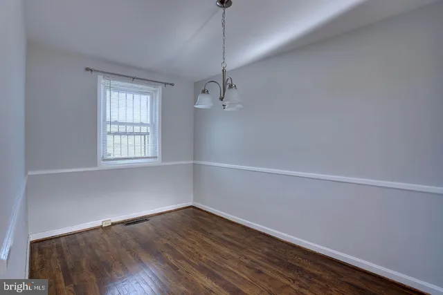 a kitchen with stainless steel appliances a refrigerator and a wooden floor